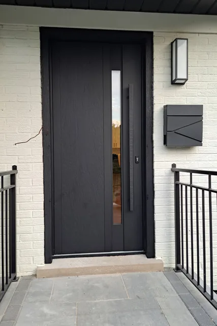 Black entry door with narrow vertical glass