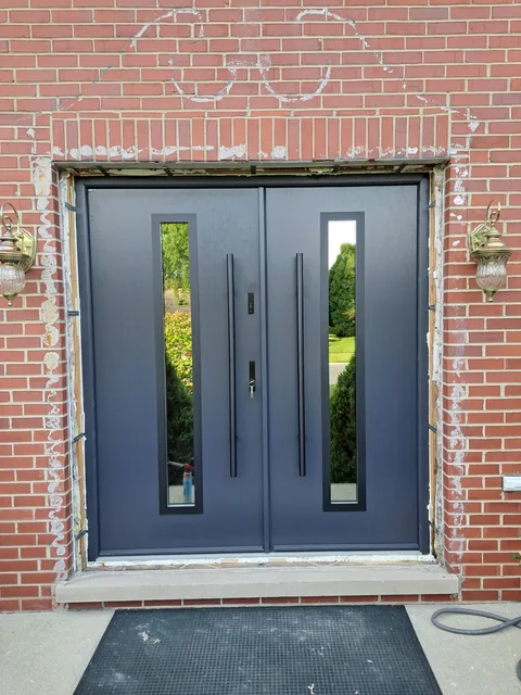 Charcoal double entry doors in a brick entrance